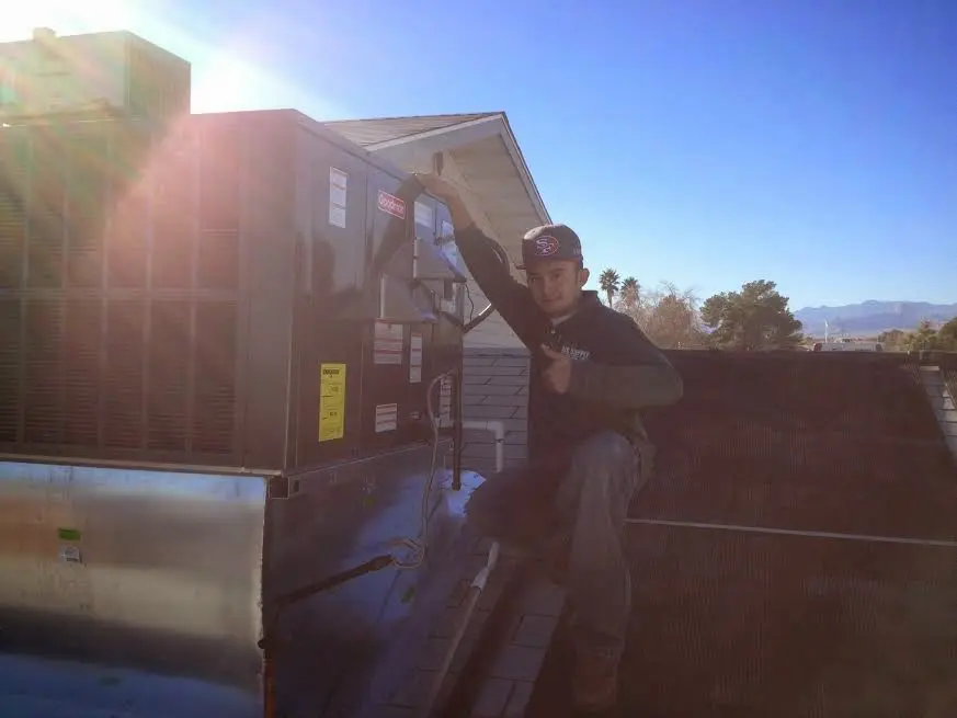 HVAC technician performing Boiler Repair on a rooftop unit in La Plata